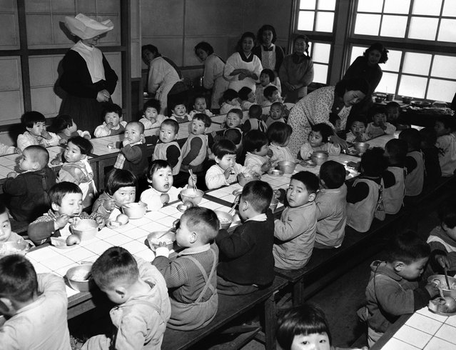 Ruang makan di sebuah panti asuhan di Osaka, Jepang, pada 19 Februari 1951, dimana 160 orang anak yatim piatu diberi makan setiap hari yang dibiayai oleh the Wolfhounds, resimen infanteri ke-27 dari angkatan darat Amerika Serikat. (Photo by Jim Pringle/AP Photo via The Atlantic)