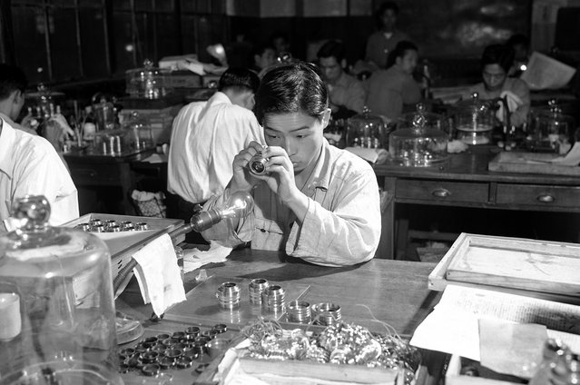 Sebuah lensa sedang diperiksa di pabrik kamera Nikon di Tokyo, 5 Januari 1952. (Photo by Bob Schutz/AP Photo via The Atlantic)