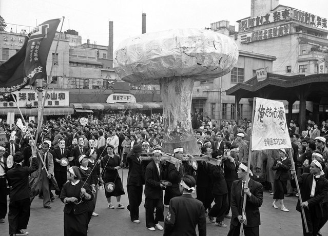 Sebuah replika raksasa dari sebuah awan jamur bom Hiroshima diarak sepanjang jalan di Tokyo, Jepang, pada 1 Mei 1957, dalam sebuah aksi memprotes rencana uji coba bom atom Inggris di Pulau Christmas. (Photo by AP Photo via The Atlantic)