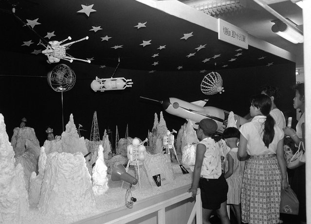 Para anak-anak Jepang ini dengan antusias melihat pameran luar angkasa di sebuah department store di Tokyo, pada 19 Agustus 1958. Mereka melihat sebuah roket yang mendarat di permukaan bulan, makhluk-makhluk aneh, bahkan satelit yang mengitari bulan. n, strange looking people of the moon walking around, and even a satellite going around the moon. (Photo by AP Photo via The Atlantic)