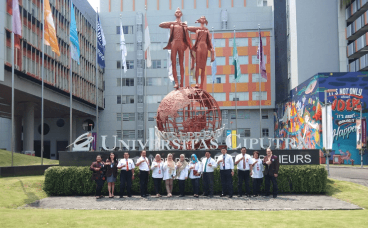 Kampus Universitas Ciputra Surabaya dengan patung ikonik di depan kampus.